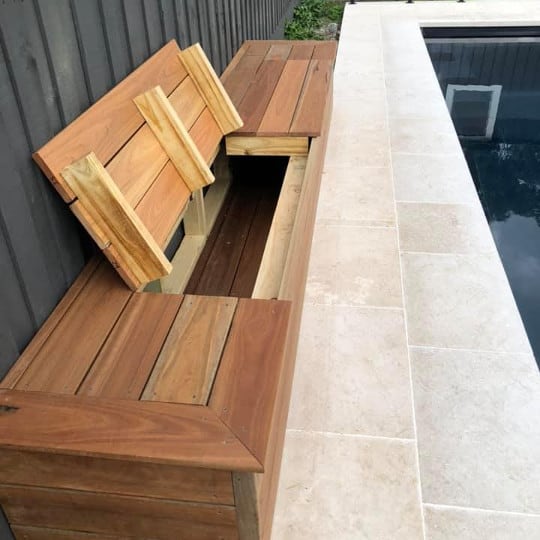 Timber swimming pool seat with lid open for storage